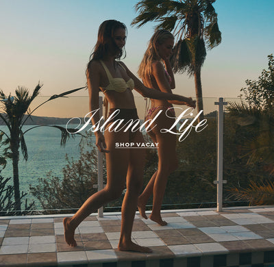 2 girls wearing bikinis by the pool.